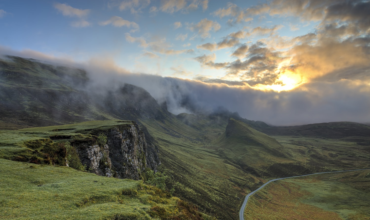 Morning mist drifting across green highland ridges